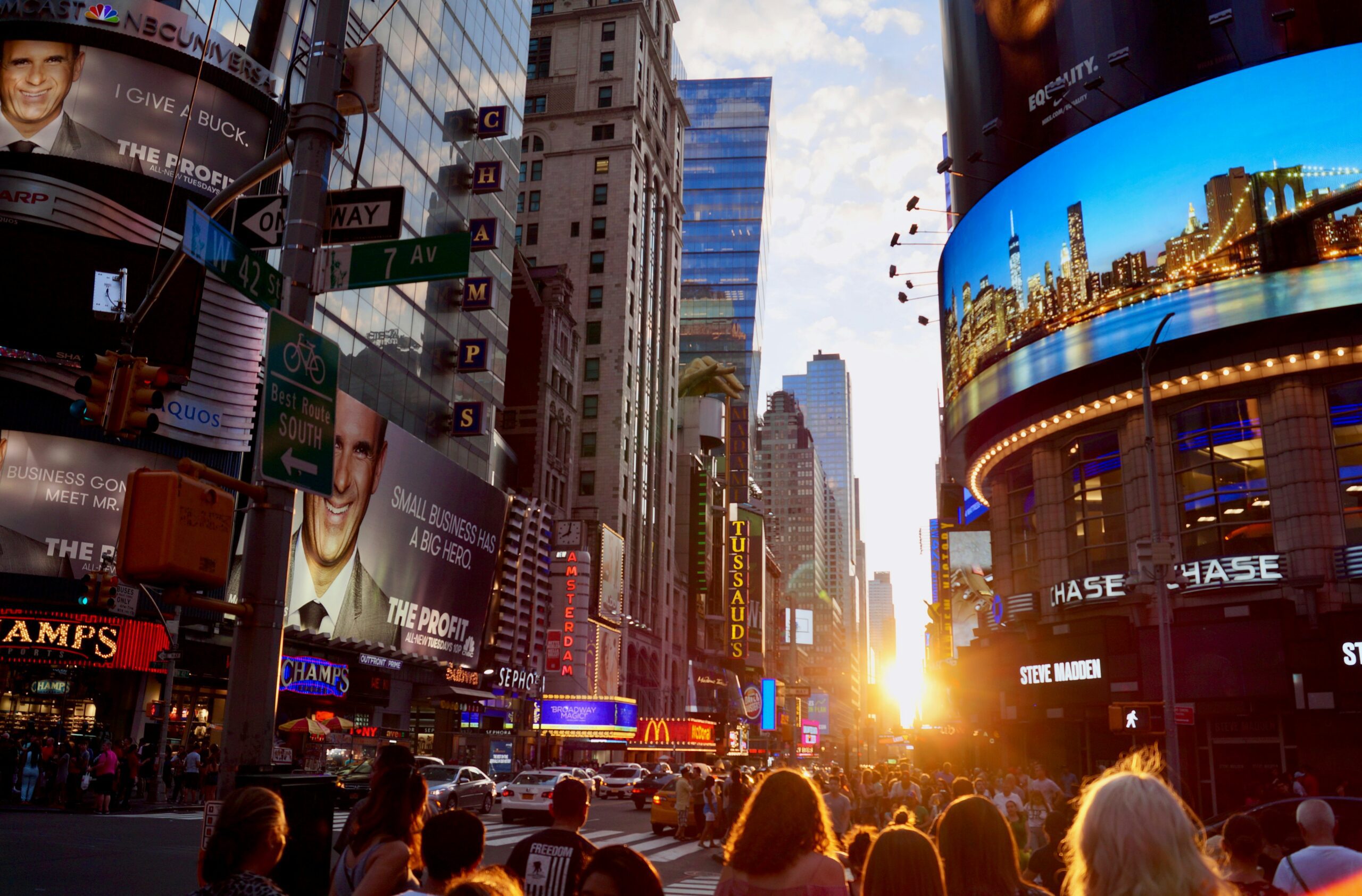 Times Square New York at golden hour with crowds and LED billboards